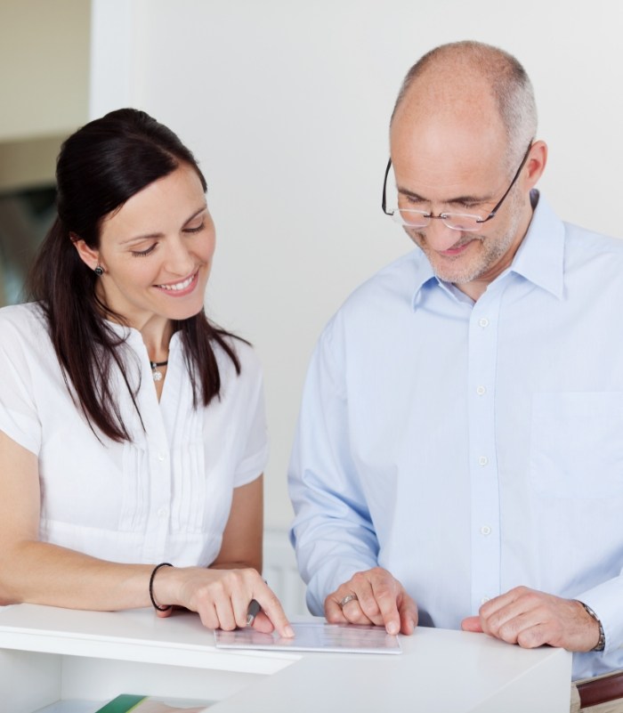 Dental team member and dentistry patient discussing the cost of dental emergencies