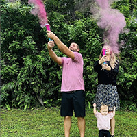 Two people with pink smoke cannisters