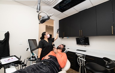 Dental team member getting dentistry patient settled in dental treatment room in Royal Palm Beach