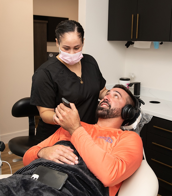 Dental team member talking to dentistry patient during dental checkup and teeth cleaning visit