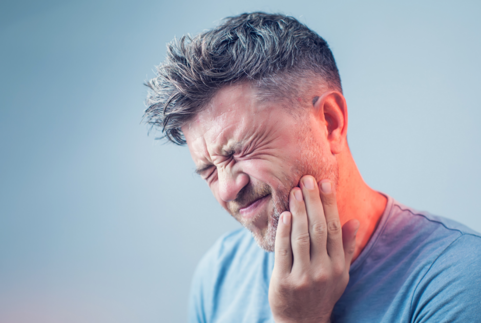 Man holding jaw in pain